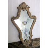 A small shield shaped wall mirror with shaped moulded and scrolled surround, 54cm high x 32cm wide