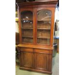 A Victorian mahogany library bookcase, the lower section enclosed by a pair of arched moulded