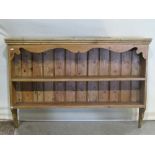A stripped pine wall mounted kitchen plate rack, with two fixed shelves and tongue and groove