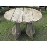 A rustic weathered oak, or possibly elm, garden table, of circular form raised on shaped and