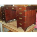 A reproduction mahogany kneehole twin pedestal writing desk in the military/campaign style with