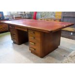 A substantial abbess A201 teak kneehole twin pedestal desk, the overhanging rectangular top with