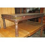 A rustic Indian hardwood low occasional table of rectangular form with moulded detail and brass