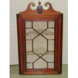 A 19th century mahogany hanging corner cabinet enclosed by an astragal glazed panel door,