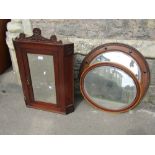 An Edwardian walnut hanging corner cupboard enclosed by a rectangular mirror panelled door flanked