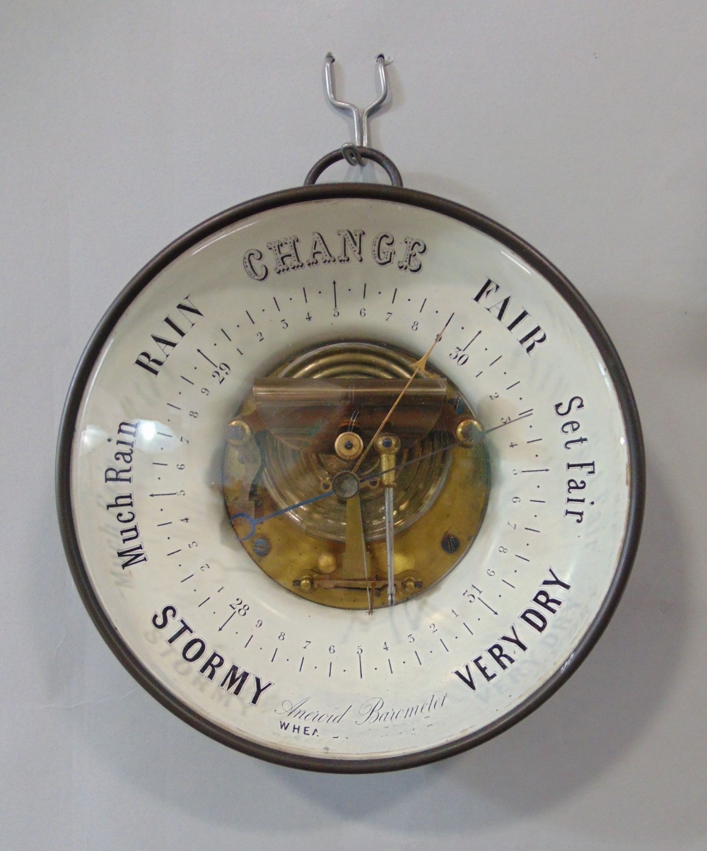 Glazed aneroid barometer with open workings and inscribed glass front, 20cm diameter