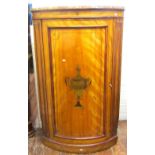 A Georgian floor standing satinwood veneered bow fronted corner cupboard, enclosed by a