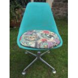 A retro material covered moulded fibreglass swivel chair with pad seat, raised on cast aluminium