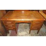 A vintage oak kneehole desk fitted with an arrangement of six drawers disguised as seven, with