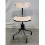 An industrial swivel typists/work chair with adjustable back raised on four arched tubular