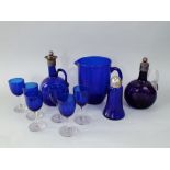 Two similar blue and amethyst glass wine flasks with white metal collars and stoppers together