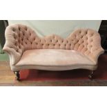 A Victorian sofa with shaped outline, upholstered finish, button back and scrolled cabriole