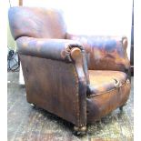 A pair of Edwardian library chairs with original leather upholstery (some repair necessary) raised