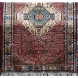 Full pile Persian rug with central teal medallion upon a washed red ground, 180 x 120 cm