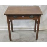 An antique oak side table fitted with a shallow frieze drawer raised on four square cut and