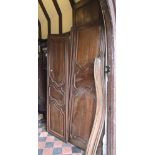 A large antique French chestnut armoire enclosed by two panelled doors with carved and moulded