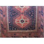 Cashmere full pile rug decorated with a central medallion upon a burnt orange ground, 200 x 140cm