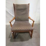 A vintage Parker Knoll rocking chair with stained beechwood frame, shaped arms, ladderback and loose