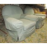 A pair of substantial easy chairs with swept arms, arched backs and later loose covers
