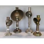 A collection of five various candle/student lamps, each with shades, one inscribed A Bartlett & Sons