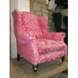 A contemporary wing armchair in the traditional style with shaped outline and floral patterned