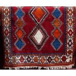 Full pile Turkish rug with multi-coloured diaper decoration upon a red ground, 230 x 130 cm