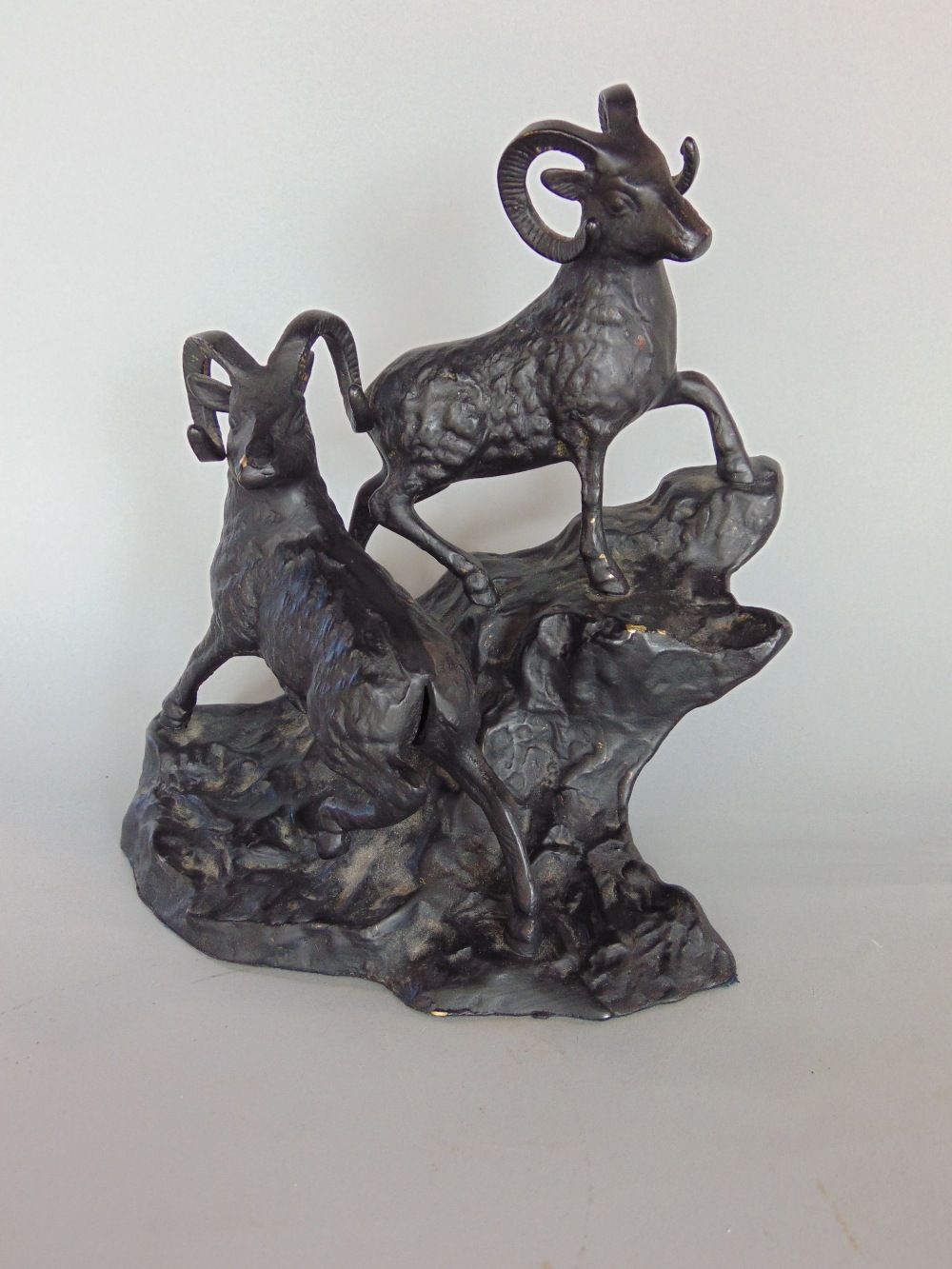 Ebonised cast brass/bronze study of two mountain goats on a naturalistic base, 20cm high