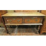 An Old English oak side table enclosing two deep frieze drawers, crossbanded in walnut, raised on