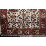 Very full pile Eastern carpet decorated with floral sprays upon a cream ground with running red