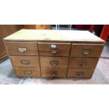 A nest of nine pine and beechwood framed office index filing drawers, 88cm wide x 43cm high x 46cm