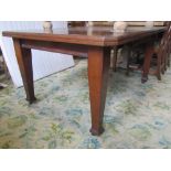 An Edwardian Arts & Crafts style mahogany wind out extending dining table of rectangular form with