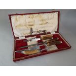 A cased set five piece horn handled carving set together with a corkscrew