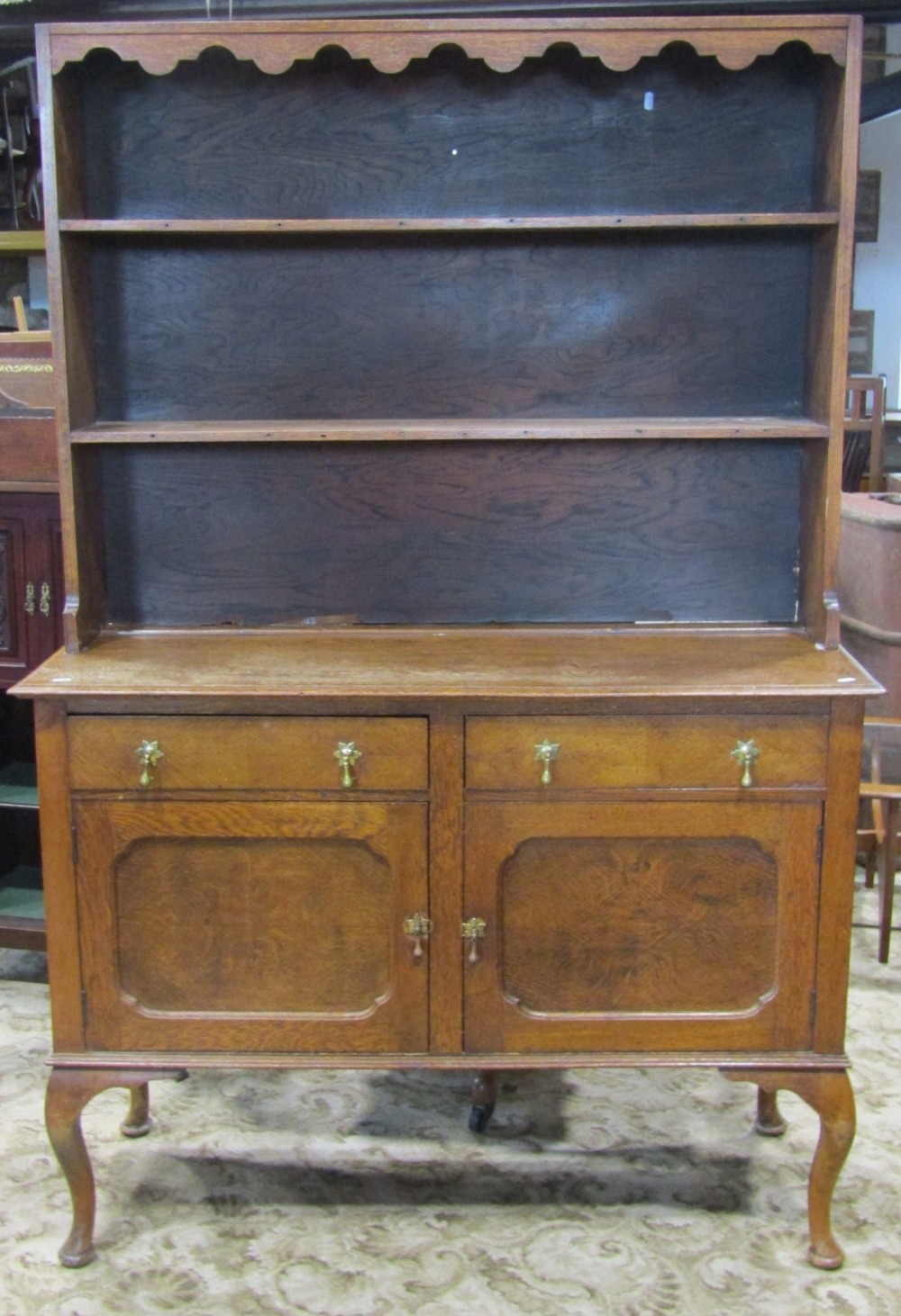 An Edwardian stained oak dresser, the base enclosed by a pair of rectangular moulded panelled