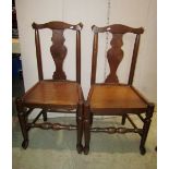 A pair of Georgian oak dining chairs with yoke shaped rails, vase shaped splats, solid seats