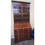 A Georgian mahogany bureau bookcase, the bureau of four long graduated drawers, the fall flap
