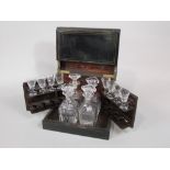 19th century ebonised decanter box, the hinged lid and front enclosing four matched decanters and