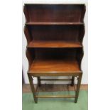 A Georgian style mahogany waterfall book stand on three tiers, raised on an open framework with