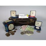 A case containing a collection of various vintage coins and notes to include sterling silver