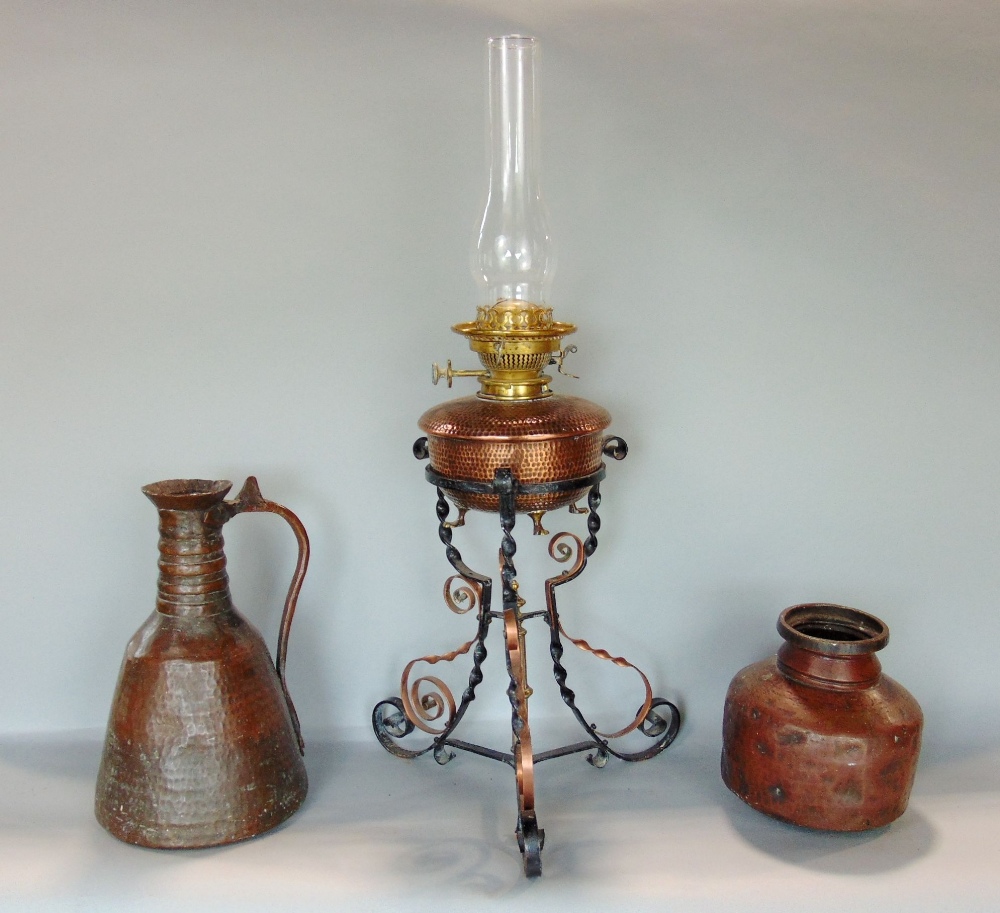 Benham & Froud planished copper oil lamp upon a barley twist wrought iron and copper tripod stand,