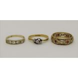 Three gold rings comprising an 18ct three stone diamond crossover example - 2g, together with a