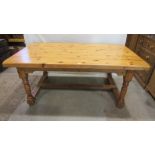 A substantial pine kitchen table, the thick rectangular top with rounded corners raised on four