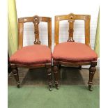 A set of eight Victorian oak framed dining chairs with carved and pierced splats, upholstered seats,