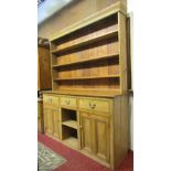 A vintage stripped pine kitchen dresser, the base enclosed by a pair of twin moulded rectangular