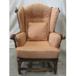 An Ercol elm armchair in the old English style, the winged back with turned spindles and arcaded
