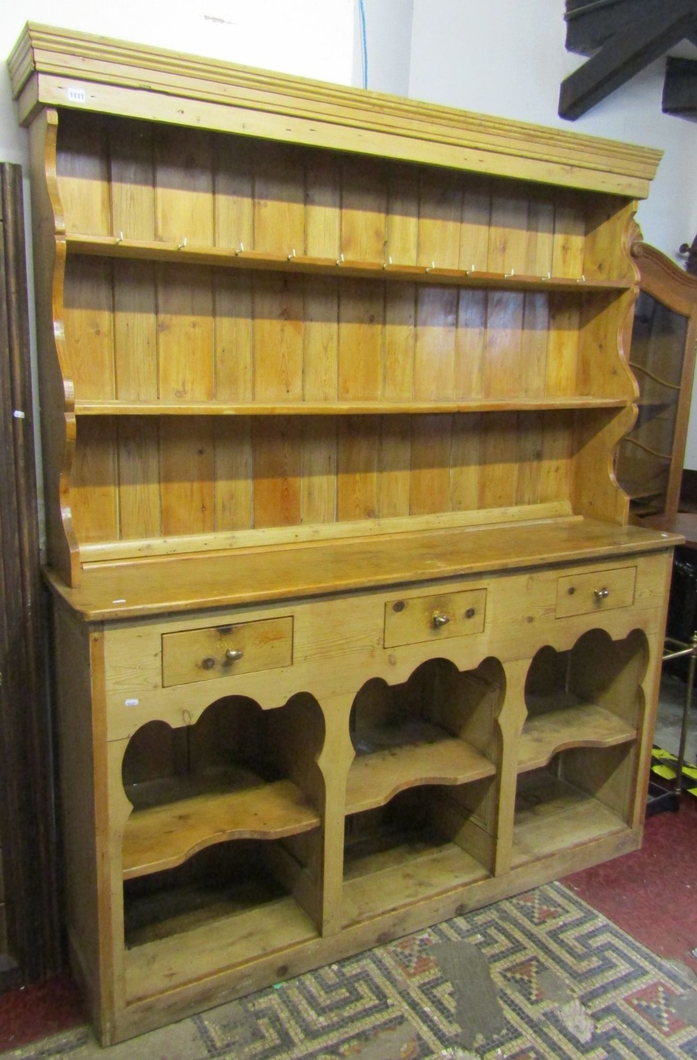 A stripped and waxed pine farmhouse kitchen dresser, the base fitted with three frieze drawers