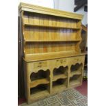A stripped and waxed pine farmhouse kitchen dresser, the base fitted with three frieze drawers
