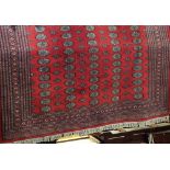 Good quality Bokhara carpet with typical geometric medallion decoration upon a red ground, 300 x 260