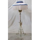 A polished brass telescopic oil lamp standard with copper flower head detail, scrolled tripod