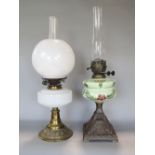 An early 20th century brass and opaline glass oil lamp with glass globular shade and reservoir, 44