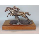 Bronze character group by Harriet Glen, of a jockey on horse back leading a fence upon a stepped